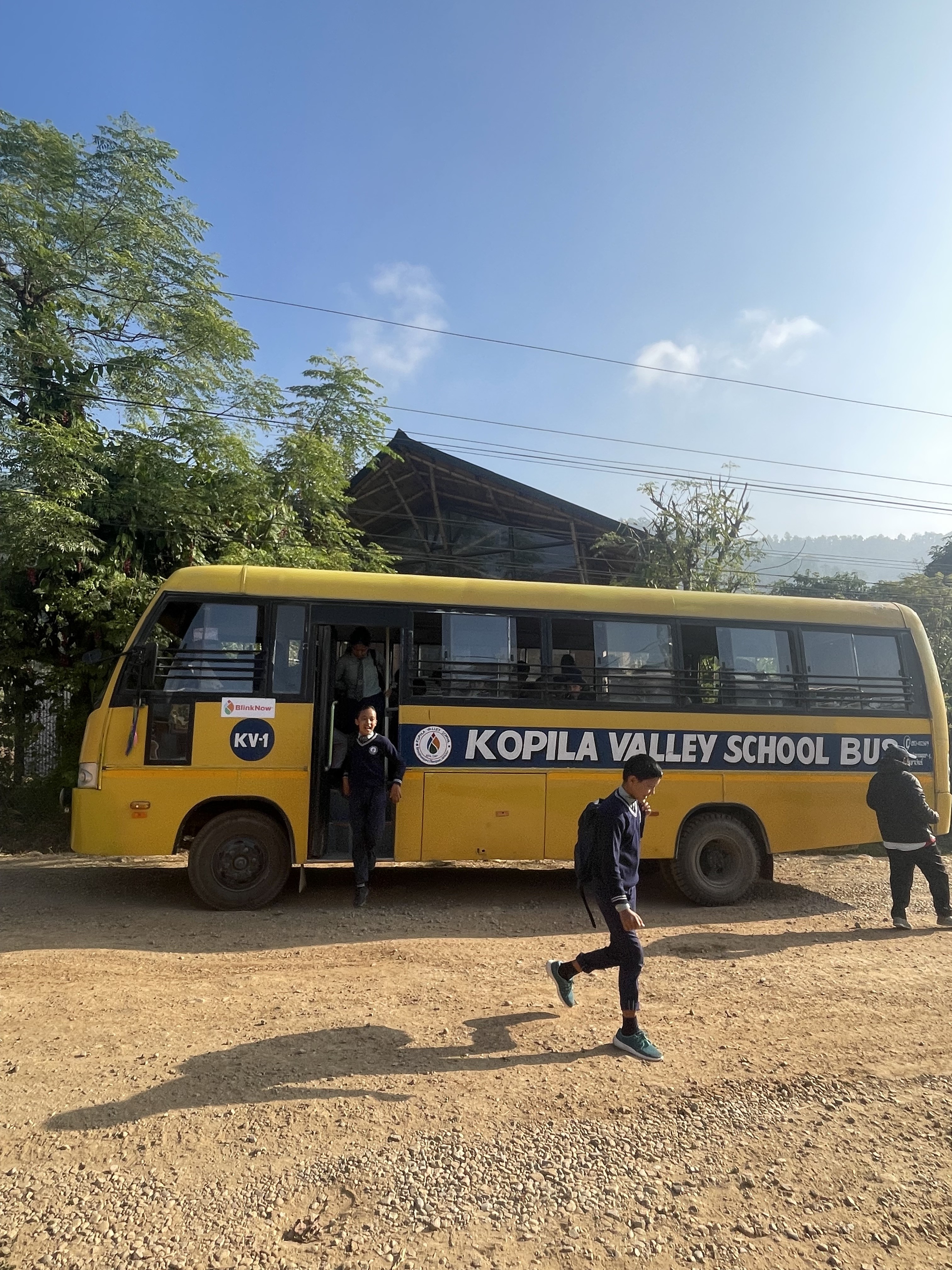 Children get off the Kopila Valley School bus.